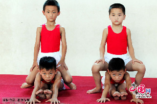 7月30日，在安徽省亳州市文帝东路亳州体操训练基地体操馆内，孩子们正在教练的指导下强化训练。图为小队员们在分组进行基本功训练。中国网图片库 刘勤利摄