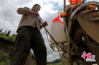 图为一村民在找到的水源点用摩托车拖水。摄影：中国网图片库 卢维