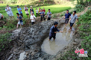 图为村民们在水源点挖临时的蓄水池。摄影：中国网图片库 卢维