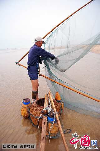 一位渔民正在清理捞出来的小虾。  中国网图片库 刘明照/摄