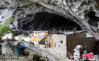 这是中洞内没有屋顶的篱笆屋，不远处的水桶是洞中人用来接洞顶滴落的泉水的。  中国网图片库  卢维/摄