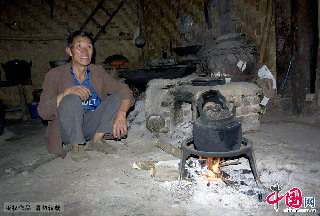 中洞内，一位老人正在生火烧水做饭。  中国网图片库  卢维/摄