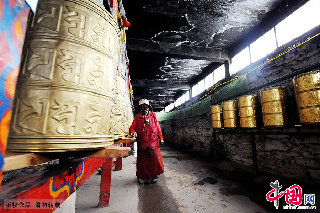 白塔内，一位藏民在转经筒。  中国网图片库  赖鑫琳/摄