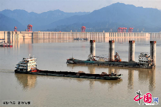 2013年8月6日，幾艘船舶通過三峽大壩壩前水域準備過閘，引航柱上水位消落痕跡清晰可見。中國網圖片庫 張國榮 攝