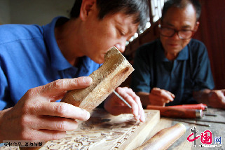 夏明月（右）在指導徒弟于建軍雕刻木版。   中國網圖片庫 金月全/攝