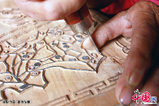 夏明月在雕刻木版年畫的木版。  中國網圖片庫 金月全/攝