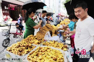 8月8日，宁夏全区220多万回族群众举行隆重的节日会礼，欢度伊斯兰教的传统节日开斋节。图为正在购买特色食品的回族群众。摄影：祁瀛涛/中国网图片库