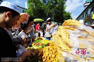 8月8日，宁夏全区220多万回族群众举行隆重的节日会礼，欢度伊斯兰教的传统节日开斋节。图为正在购买特色食品的回族群众。摄影：祁瀛涛/中国网图片库