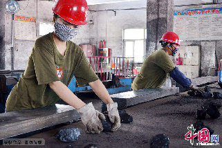 任丹丹（左一）用双手一块块扒开矸石，使煤炭与矸石分离，将煤炭分拣出来回收使用。  中国网图片库 黄世鹏/摄