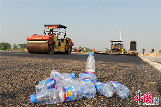 2013年8月11日，立秋虽过，安徽省亳州市“秋老虎”持续多日发威，骄阳似火，最高气温达到38摄氏度以上，而在经济开发区道路建设施工一线的筑路工们正在进行沥青路面摊铺，施工人员不畏高温，在头顶烈日、脚踩滚烫沥青的双重“烤”验下，奋战在施工一线。图为由于天气炎热，筑路工饮用矿泉水的水瓶。  中国网图片库 张延林摄影