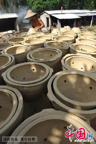 老人将窑子里烤好的陶器取出。中国网图片库 蒙钟德/摄