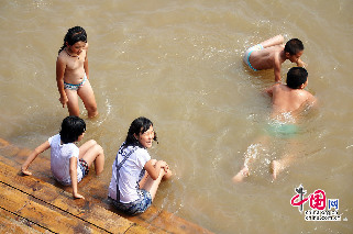 吉林松花江水位上涨，亲水长廊变身游泳池。图为2013年8月12日，在吉林省吉林市松花江畔，一些孩子把亲水长廊当成游泳池，在江水中嬉戏玩耍。摄影：中国网图片库 王明铭