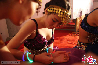 身材丰满的舞者正在整理荧光棒的手链。中国网图片库 吕斌摄