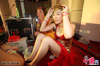 登台前演员要调整自己的头饰，避免跳舞的时候发生脱落。中国网图片库 吕斌摄