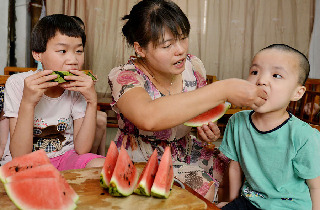 2013年8月14日，义乌市赤岸镇尚阳村爱心妈妈毛菊云的女儿朱俊芳也时常过来帮忙照料收养在家里的残疾孩子。中国网图片库 张建成摄