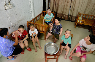 2013年8月14日，义乌市赤岸镇尚阳村爱心妈妈毛菊云，精心料理收养在家里的残疾孩子。中国网图片库 张建成摄