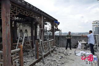 2013年8月19日，江苏苏州，一支施工队伍正在拆除位于江苏苏州市三香大厦高楼18层楼顶东侧阳台的苏州园林式违建别墅。 中国网图片库 季则摄影