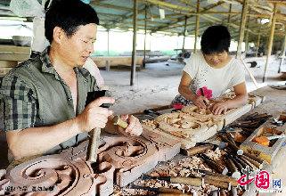 東陽木雕師傳將在拆遷運輸過程中損壞的木雕組件依樣修復。  中國網圖片庫   張建成/攝