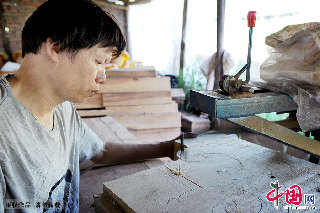 东阳木雕师傳将在拆迁运输过程中损坏的木雕组件依样修复。   中国网图片库  张建成/摄