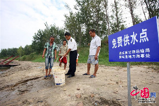 8月20日，安徽省蒙城县涡河岸边，被困船民从岸上的免费供水点取水。中国网图片库 胡卫国摄影