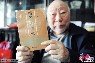 收藏家藍翔在展示他的第一部著作《筷子古今談》，這也是我國首部筷子文化專著。  中國網圖片庫 賴鑫琳/攝