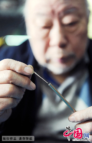 蓝翔在展示一双短小的清代银筷子。  中国网图片库 赖鑫琳/摄