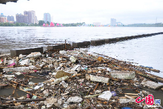 受近日吉林市丰满水库泄洪影响，大量漂浮垃圾从上游流进吉林市临江门大桥下的护栏台内，对江水造成严重污染。图为8月26日，吉林省吉林市临江门大桥下江面上成堆的漂浮垃圾。  中国网图片库 王凯冬摄影