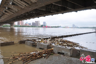 受近日吉林市丰满水库泄洪影响，大量漂浮垃圾从上游流进吉林市临江门大桥下的护栏台内，对江水造成严重污染。图为8月26日，吉林省吉林市临江门大桥下江面上成堆的漂浮垃圾。  中国网图片库 王凯冬摄影