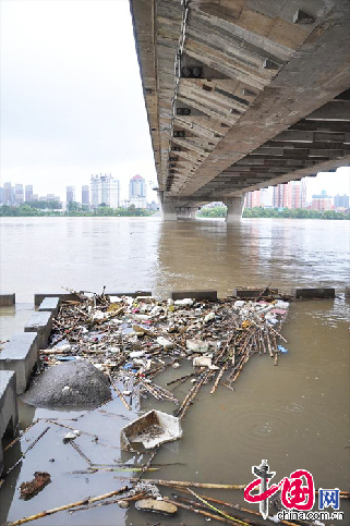 受近日吉林市丰满水库泄洪影响，大量漂浮垃圾从上游流进吉林市临江门大桥下的护栏台内，对江水造成严重污染。图为8月26日，吉林省吉林市临江门大桥下江面上成堆的漂浮垃圾。  中国网图片库 王凯冬摄影