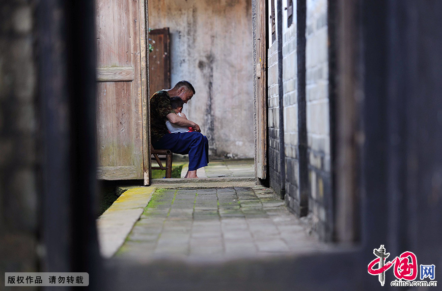 一位老人抱着孩子在关西围屋内纳凉。 中国网图片库 赖鑫琳/摄