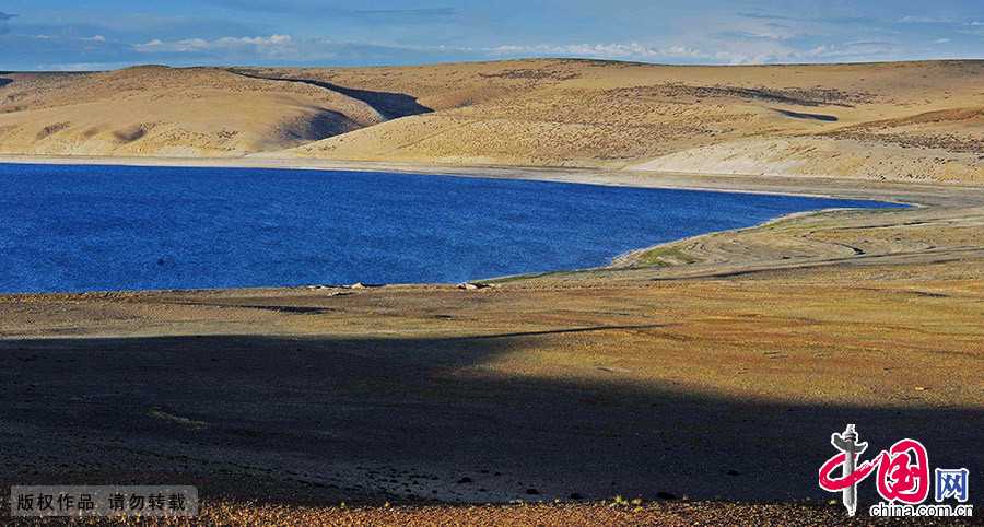 拉昂措湖一角。拉昂措藍色的湖水與湖邊褐色的砂石形成鮮明的對比。 中國網圖片庫 賴鑫琳/攝