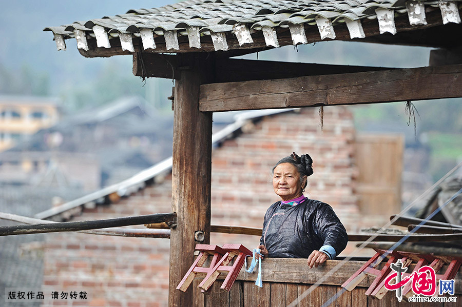 在家中的阳台上，68岁的潘萨银花老人一边回忆一边唱着侗歌。中国网图片库 赖鑫琳/摄 
