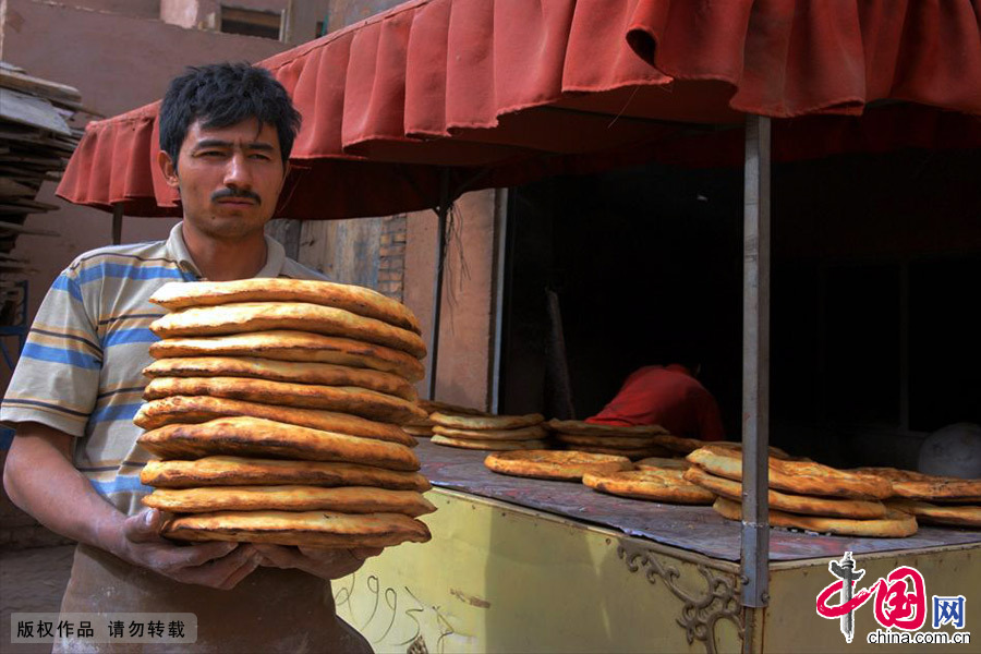  烤馕是吐鲁番维吾尔族最主要的面食品。“可以一日无菜，但决不可以一日无馕。”足以证明馕在维吾尔族人民生活中的重要地位。中国网图片库 郑跃芳/摄