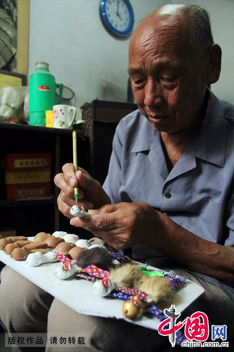 今年87岁的魏义民老人眼不花，手不抖，捏造缝制泥猴的手艺十分熟练。中国网图片库 杨正华/摄