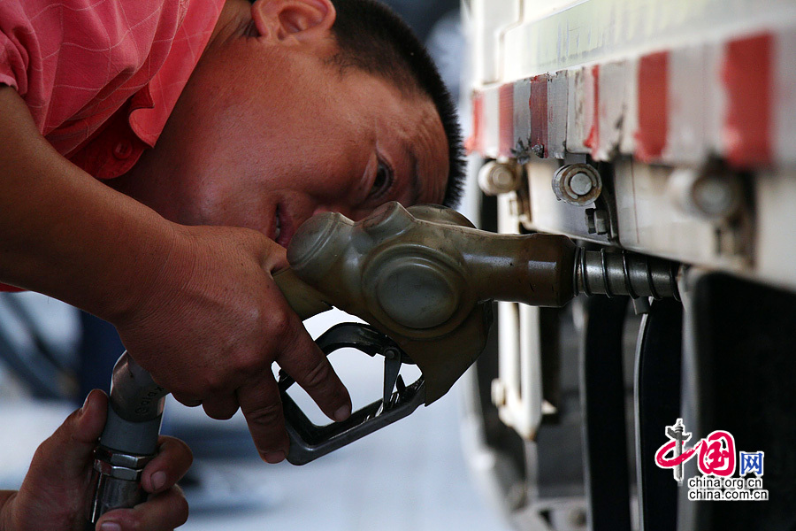 2013年9月13日，山東濱州，市民在一加油站為車輛加油。