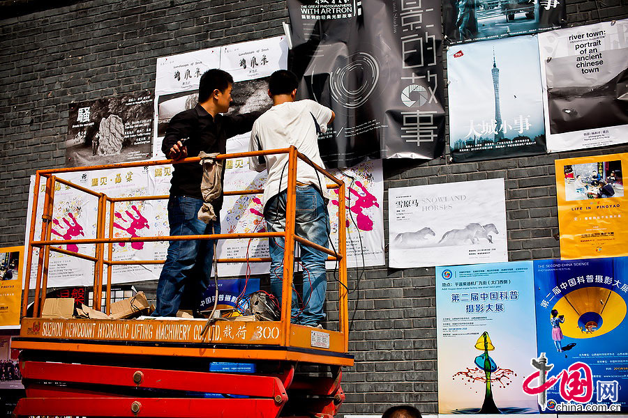 柴油机厂展区门口，正在贴海报的工作人员。中国网记者 郑亮摄