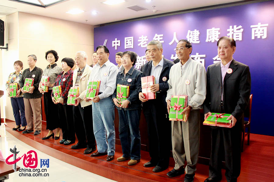 2013年9月26日，2013年全国“敬老月”活动在京启动。启动仪式上，由全国老龄工作委员会办公室、国家卫生和计划生育委员会共同编印的《中国老年人健康指南》新闻发布会也同时举行。图为老年人代表获赠《中国老年人健康指南》。 中国网记者 戴凡/摄影
