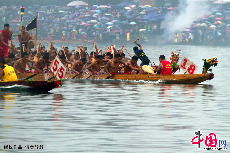 融安第十五届龙舟节上，龙舟激烈争夺赛在雨中进行。中国网图片库 何进文/摄