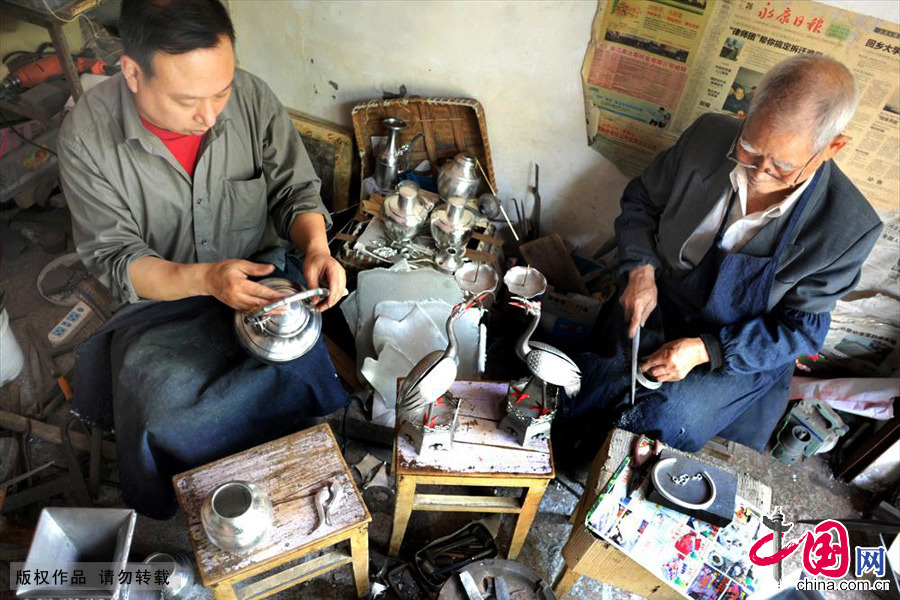 浙江永康芝英镇84岁的应业根与儿子应华升忙着为台湾一客商赶制锡雕工艺品。中国网图片库 张建成/摄