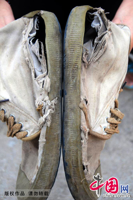 9月25日，马登峰的爱人展示他穿破的胶鞋。他爱人说每年都要为登峰买几双胶鞋，怕他爬高上低脚受不了。中国网图片库 房德华/摄