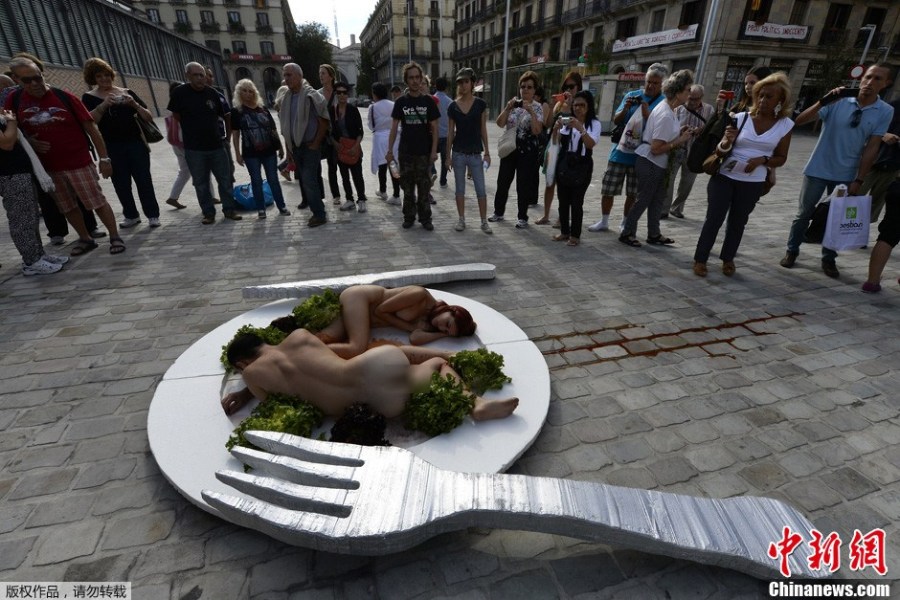 当地时间10月2日，西班牙巴塞罗那，当地动物保护组织成员现身街头裸身当“盘中餐”，推广素食主义。