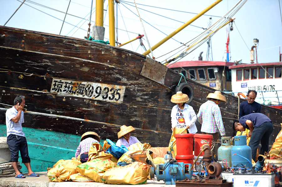 2013年10月4日，海南琼海，渔民正在潭门港码头搬运行李。当天上午，受台风“蝴蝶”袭击的海南琼海市渔船已陆续安全返回潭门港。