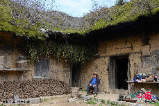 三峡库区奉节县长安土家族乡五坝村高发常坐在茅草屋下休息。 中国网图片库 周会/摄