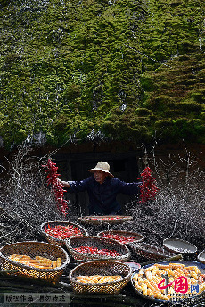 10月7日，村民在草屋下晾晒辣椒。 中国网图片库 周会/摄