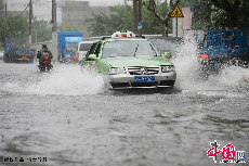 一辆出租车行驶在积满雨水的上海市杨树浦路武宁路段。中国网图片库 赖鑫琳/摄