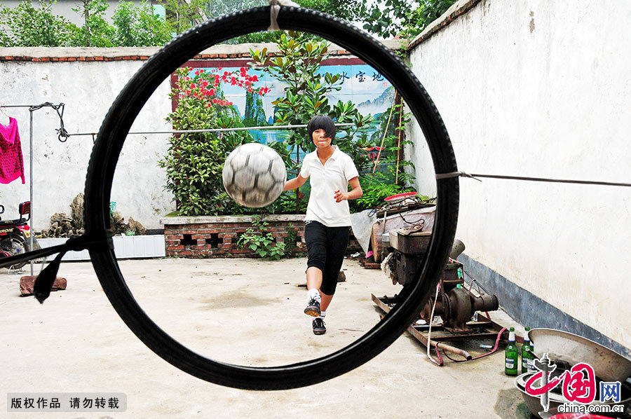 即使在家里，尚良慧也不忘练习。她在院子里系上自行车胎来练习射门。中国网图片库 房德华/摄 