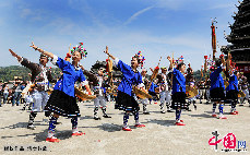 在芦笙大赛上，参赛队员跳起芦笙踩堂舞。芦笙踩堂舞为大型集体舞，场面宏大，用芦笙多达上千支。 中国网图片库 谭克兴/摄