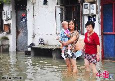浙江省寧波市江東區居民在水中等待救援船隻轉移。 中國網圖片庫 胡學軍/攝