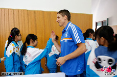 皇家马德里球员杰西.卡罗尔（Jaycee Carroll）与学生击掌。 中国网 杨佳/摄