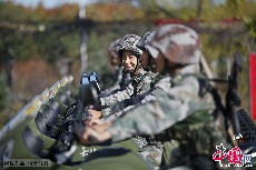 战士们骑着摩托车准备进行野战条件下驾驶训练，一位年轻的战士对着镜头露出灿烂的微笑。 中国网图片库  魏建顺/摄